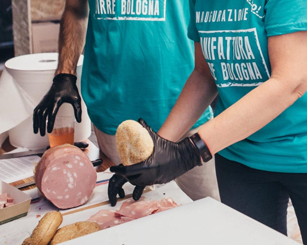 Il team di Manifattura birre Bologna taglia la mortadella per il tagliere da servire come aperitivo per accompagnare la birra